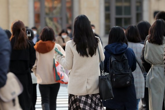 단계적 일상회복(위드코로나) 전환이 가까워지고 있는 가운데 지난 21일 오전 서울 세종대로 사거리에서 손에 핫팻을 든 시민이 출근길 발걸음을 재촉하고 있다. 뉴스1 제공.