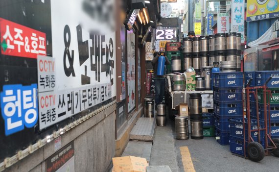 정부가 '위드코로나'와 관련해 구체적인 방역 완화 계획안을 발표한 25일 서울의 한 유흥거리에서 관계자가 맥주 박스를 옮기고 있다. © News1 이성철 기자