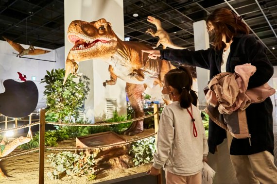 국립부산과학관 김진재홀에서 진행하는 '다이노소어' 특별기획전을 관람하는 어린이가 부모와 함께 다양한 공룡의 모습을 살펴보고 있다. 부산과학관 제공