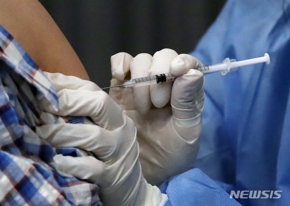 한 시민이 코로나19 백신을 접종하고 있다. 뉴시스