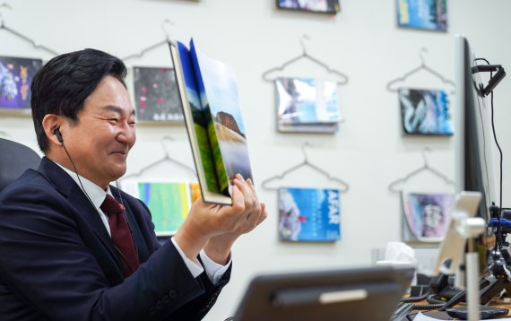 원희룡 전 제주지사는 지난 5월20일 인슬리 미국 워싱턴주지사와 화상회의를 열고, 탄소중립 위한 글로벌 기후연합체 가입을 약속했다.원희룡 전 지사가 사진으로 들고 제주를 소개하고 있다.(제주도 제공)© 뉴스1