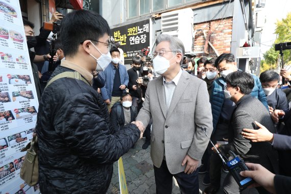 이재명 더불어민주당 대선 후보가 5일 오전 대구 북구 경북대학교 인근에 도착해 첫 일정으로 예정된 '대구 청년 명수씨와 식사'를 앞두고 음식점 앞에서 '나도 대통령 친구가 있었으면 좋겠다'라는 피켓을 들고 마중 나온 백명수씨와 인사 나누고 있다. 사진=뉴스1