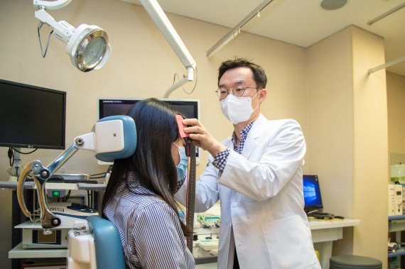 이대목동병원 이비인후과 이호윤 교수가 만성 이명 환자에게 전기자극치료를 실시하고 있다. /사진=뉴시스