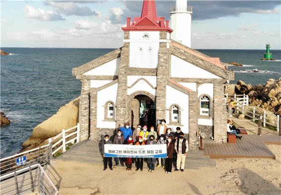 부산 기장군 죽성 드림세트장에서 진행된 동서대 에버그린 에이전시 드론체험 교육 참가자들이 기념촬영을 하고 있다. 동서대학교 제공