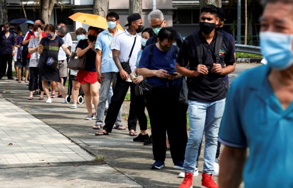 21일(현지시간) 싱가포르에서 마스크를 쓴 시민들이 신종 코로나바이러스 감염증 신속항원검사를 받기 위해 줄 서 있다. 사진=뉴스1