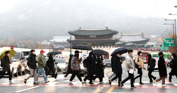 기상청은 10일 서울에 첫눈이 내렸다고 공식 발표했다. 지난해보는 한달 빠른 첫눈이다. 이날 오전 시민들이 서울 광화문 앞 횡단보도를 건너고 있다. 뉴시스