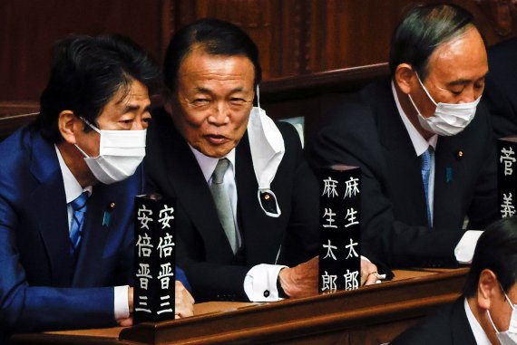 지난해 11월 10일 일본 국회에서 아베 신조 전 총리와 아소 다로 자민당 부총재가 대화를 하는 모습. 그 옆으로 스가 요시히데 전 총리의 모습이 보인다. 로이터 뉴스1
