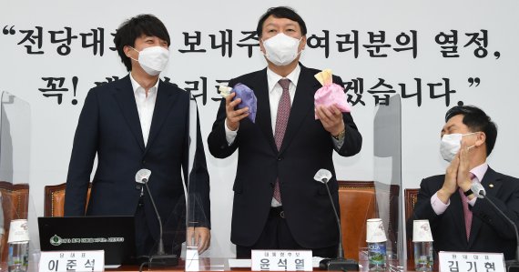 윤석열 국민의힘 대선후보(왼쪽 두 번째)가 지난 8일 오전 서울 여의도 국회에서 열린 최고위원회의에서 이준석 대표에게 비단주머니를 받은 후 발언하고 있다. 2021.11.8/뉴스1 © News1 이동해 기자