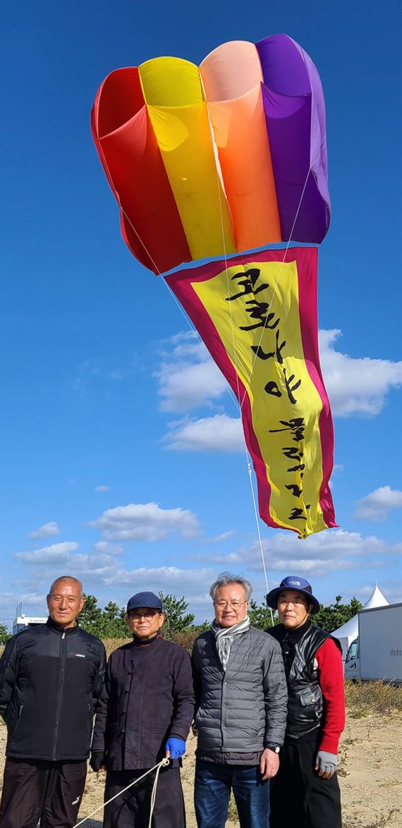 태안군 2021년 사구축제 및 솔향기 축제행사의 메인 연날리기 명장들이 “코로나야 물렀거라!” 파라포일 대형연을 시연했다. 오른쪽부터 한국연협회 양재진 이사, 리기태 회장, 강연중, 홍동희. 사진=한국연협회·리기태연보존회