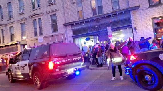 미국 위스컨신주 와키셔 주민들이 21일(현지시간) 산타 퍼레이드 차량 돌진 사고와 관련해 경찰에게 사건 상황을 설명하고 있다. 로이터뉴스1