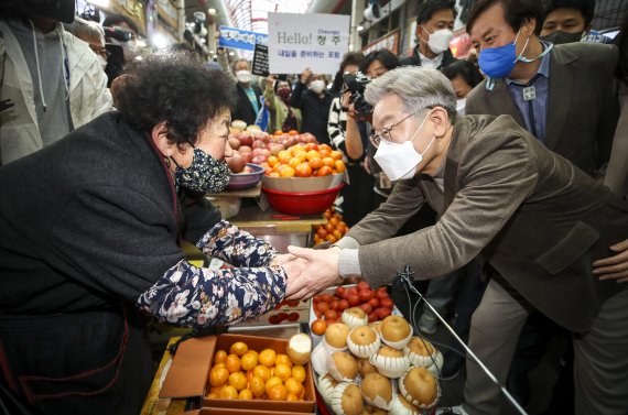 [청주=뉴시스] 정병혁 기자 = 이재명 더불어민주당 대선 후보와 부인 김혜경 씨가 21일 오후 충북 청주시 육거리종합시장을 찾아 과일을 구매하고 있다. 2021.11.21. jhope@newsis.com