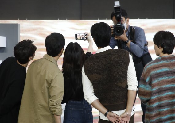 배우 한소희(가운데)가 8일 오후 부산 해운대구 영화의전당 야외극장에서 열린 제26회 부산국제영화제 초청작 '마이네임' 오픈토크를 마친 뒤 자신의 핸드폰에 팬들과 함께한 순간을 담고 있다. © News1 권현진 기자