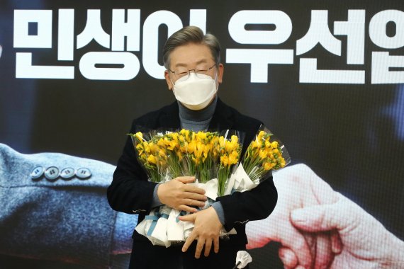 더불어민주당 이재명 대선 후보가 6일 오전 서울 여의도 중앙당사에서 열린 소상공인과 함께하는 전국민선대위에 참석한 소상공인들이 준비한 꽃을 받고 있다.