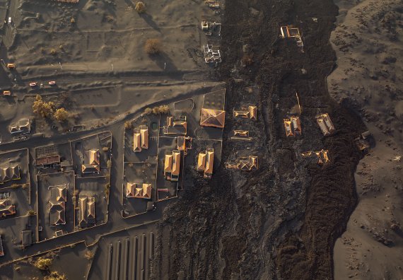 [라팔마=AP/뉴시스] 6일(현지시간) 스페인 카나리아제도 라팔마섬의 쿰브레 비에하 화산에서 용암이 흘러나오면서 라스 만차스 마을이 화산재로 덮여 있다. 2021.12.08.