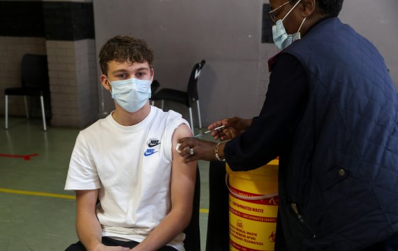 미국 식품의약청(FDA)이 9일(현지시간) 화이자 코로나19 백신 부스터샷 접종연령대를 16세 이상으로 낮췄다. 같은 날 남아프리카공화국 요하네스버그에서 한 소년이 화이자 백신을 맞고 있다. 로이터뉴스1
