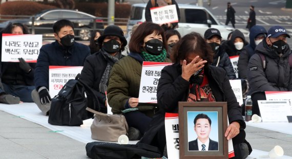 코로나19 백신 피해자가족협의회(코백회) 회원들이 11일 서울 서대문구 독립문공원 앞에서 열린 코로나19 백신피해 인과성 인정 촉구 집회에서 고인을 애도하고 있다. 2021.12.11/뉴스1 © News1 김명섭 기자