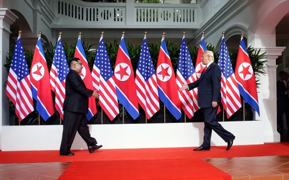 북미 정상회담이 열린 지난 2018년 6월 12일 싱가포르 센토사섬 카펠라 호텔 회담장에서 도널드 트럼프 미국 대통령과 김정은 국무위원장이 악수를 하기 위해 걸어오며 손을 내밀고 있다. 싱가포르 통신정보부 제공