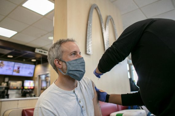 지난달 21일(현지시간) 미국 일리노이주 시카고의 한 맥도날드 매장에 마련된 백신 접종소에서 한 남성이 코로나19 부스터샷을 접종받고 있다.로이터뉴스1