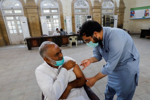 파키스탄 카라치에서 22일(현지시간) 한 남성이 코로나19 백신을 맞고 있다. 미국 연구진에 따르면 코로나19 백신 접종자 상당수가 부작용을 겪지만 심각한 부작용 위험은 매우 낮다. 로이터뉴스1