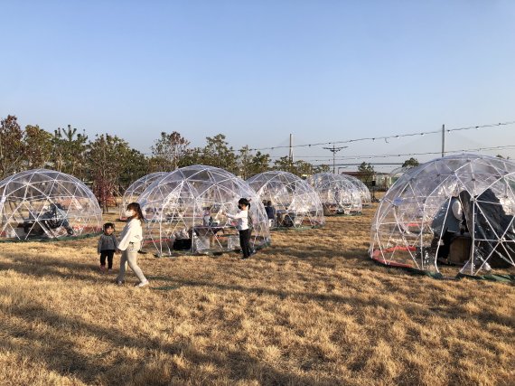 23일 개방된 부산 동구 부산항 국제여객터미널 인근 문화공원 1호에 설치된 투명이글루에서 아이들이 뛰놀고 있다.2021.12.23/© 뉴스1 백창훈 기자