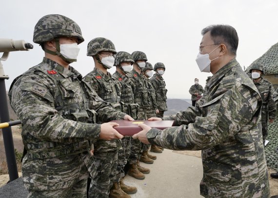 [서울=뉴시스] 문재인 대통령이 23일 오전 서해 백령도 해병대를 방문, 최전방 초소(OP)에서 근무 중인 해병대 장병들을 격려하고 겨울용품 세트를 선물하고 있다. (사진=청와대 제공) 2021.12.23. photo@newsis.com