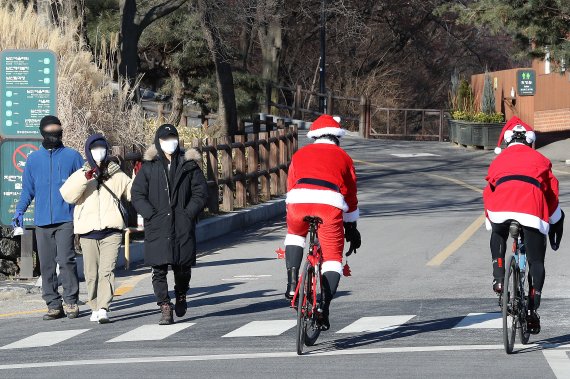 [서울=뉴시스] 백동현 기자 = 크리스마스인 25일 오전 서울 용산구 남산공원에서 자전거 동호인 김이두 씨와 김영훈 씨가 산타클로스 복장을 하고 자전거를 타고 있다. 2021.12.25. livertrent@newsis.com