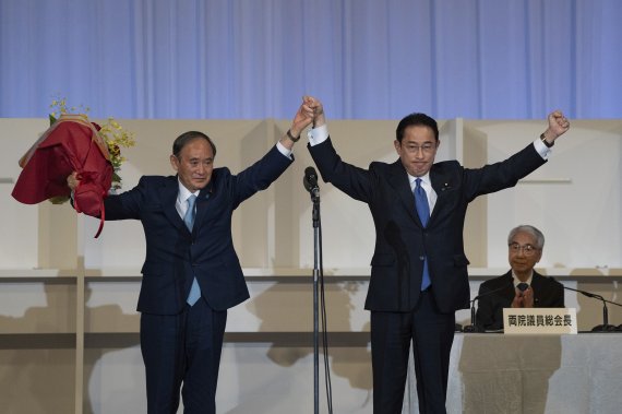 기시다 후미오 일본 총리(오른쪽)가 스가 요시히데 전 총리와 지난 9월 29일 일본 자민당 총재 선거 직후 자축하고 있다. AP뉴시스