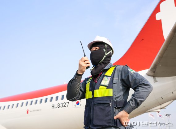 티웨이항공 정비사가 김포공항 주기장에서 새로 지급된 방한용 멀티 두건을 착용하고 항공기 정비 및 점검 업무를 진행하고 있다. 사진=티웨이항공 제공