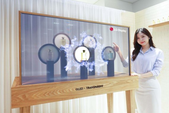 27일 LG디스플레이 모델이 투명 OLED와 진열대를 결합한 제품 프로모션용 '투명 쇼케이스'를 소개하고 있다. LGD 제공