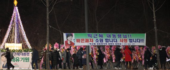 [서울=뉴시스] 조수정 기자 = 문재인 정부 5차 특별사면 대상인 박근혜 전 대통령 석방을 앞두고 지난 30일 오후 박 전 대통령이 입원하고 있는 서울 강남구 삼성서울병원 앞에서 지지자들이 석방 환영을 위해 모여 있다. 병원 인근에는 지지자들의 석방 환영 및 쾌유 기원 화환과 현수막이 늘어서 있다. 2021.12.30. chocrystal@newsis.com