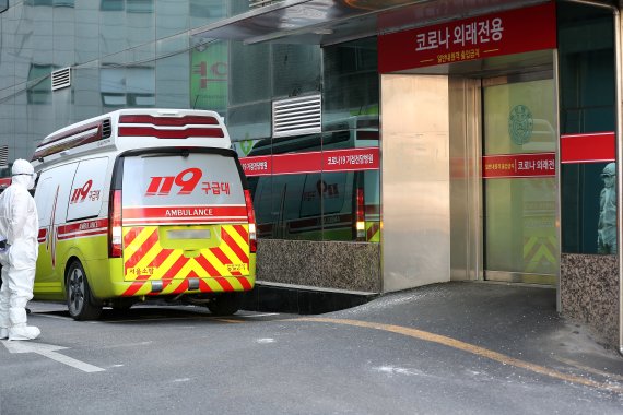 지난 1월 서울의 한 병원 앞에서 119 구급대원이 이송할 코로나19 환자를 기다리고 있다. 뉴시스