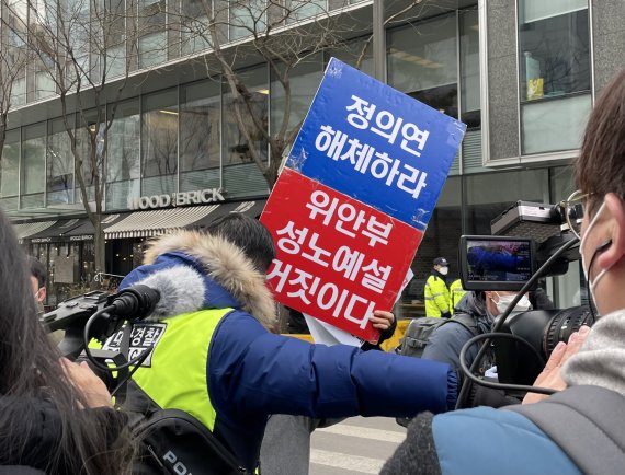 30주년 기념 수요시위가 열린 5일 낮 서울 종로구 연합뉴스 사옥 인근에서 한 보수 측 참가자가 피켓을 들고 고함을 지르는 과정에서 경찰과 충돌을 빚었다 /사진=박지연 기자