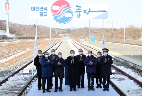 [고성=뉴시스] 전진환 기자 = 문재인 대통령이 5일 오전 강원 고성군 제진역에서 열린 동해선 강릉~제진 철도건설 착공식이 끝난 뒤 서명판에 서명한 뒤 참석자들과 기념촬영을 하고 있다. 2022.01.05. amin2@newsis.com