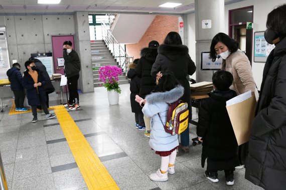 서울 장월초등학교에서 5일 ‘2022년 초등학교 신입생 예비소집’ 이 열리고 있는 가운데 신입생들과 학부모들이 서류접수 순서를 기다리고 있다. 사진=박범준 기자