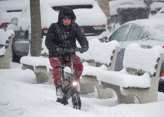 미국 뉴욕 브루클린에서 1월 7일(현지시간) 눈폭풍이 몰아친 가운데 한 남성이 전기자전거를 타고 길을 가고 있다. 로이터뉴스1