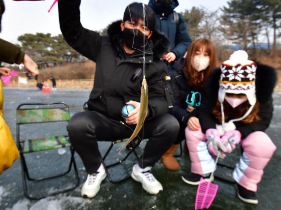 가족단위 나들이객이 빙어 낚시를 즐기고 있다. 사진=박범준 기자