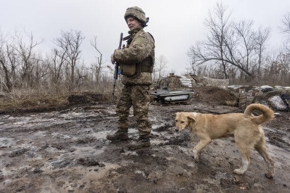 지난 2022년 1월 10일(현지시간) 우크라이나 도네츠크 지역에서 한 우크라이나군 병사가 개와 함께 친 러시아 반군과의 대치 구역을 순찰하고 있다. 사진=뉴시스