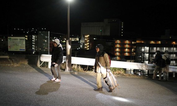 16일 새벽 일본 동북부 이와테현 지역의 주민들이 쓰나미 경보에 따라 고지대로 이동하고 있다. 로이터 뉴스1