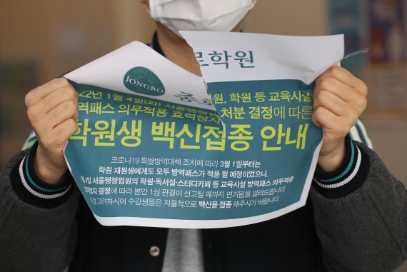 정부가 보습학원·독서실·박물관·영화관·대형마트 등의 방역패스 적용을 해제한다고 밝힌 17일 서울 마포구 종로학원 강북본원에서 관계자가 제거된 방역패스 안내문을 들고 있다. 뉴스1 제공.