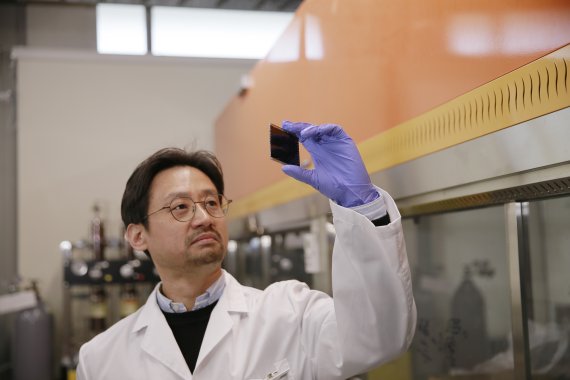 [연구진사진] 유니스트 에너지화학공학과 양창덕 교수가 모듈형태로 크기를 키운 페로브스카이트 태양전지를 들고 있다.