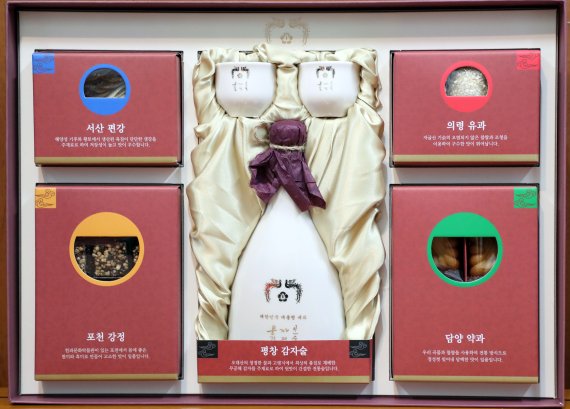【서울=뉴시스】전신 기자 = 31일 청와대가 공개한 '평창 서주(薯酒)'가 담긴 문재인 대통령의 설 명절 선물세트. 청와대 관계자는 30일 뉴시스와 통화에서 "평창동계올림픽의 성공적 개최를 기리면서 올림픽 기간과 설연휴가 겹치는 특징도 고려한 구성"이라고 선물 의미를 설명했다. 전통주는 문 대통령의 아이디어로 알려졌다. 지난해 추석 명절 선물에는 술이 빠졌는데 설 명절에는 차례상에 쓰도록 전통주를 포함하면 좋겠다는 취지다. 청와대는 평창 서주 외에 농산물 전문 기관의 추천을 받은 곡물로 설 선물세트를 구성한다. 지난해 추석 때 청와