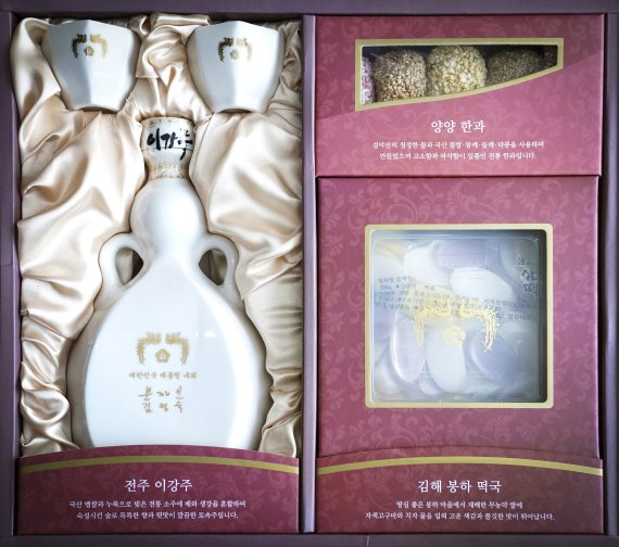 [서울=뉴시스]박영태 기자 = 문재인 대통령 내외는 설 명절을 맞아 각 분야에서 국가를 위하여 헌신하는 분들과 국가유공자, 사회적 배려계층 등 약 1만4천여 명에게 설 선물을 보낼 예정이다.사진은 전북 전주의 이강주(술), 강원 양양의 한과, 경남 김해의 떡국떡 등 지역 특산물 3종 세트로 구성된 설 선물.(사진=청와대 제공) 2020.01.10.photo@newsis.com