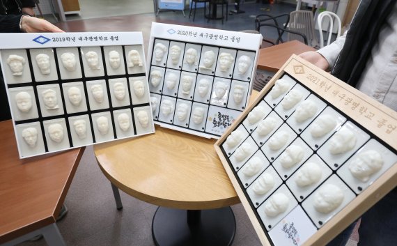 대구시 동구 신천동 대구콘텐츠센터에 입주한 경북대 크리에이티브팩토리에서 직원들이 3D프린터를 이용해 만든 대구광명학교 졸업앨범을 보여주고 있다. 왼쪽부터 2019학년, 2020학년, 2021학년 졸업앨범. © 뉴스1