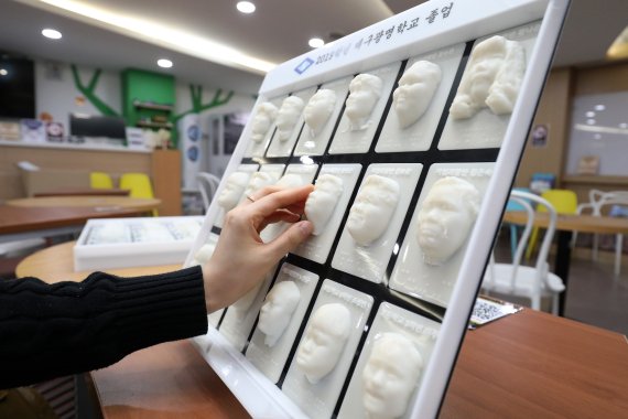 대구시 동구 신천동 대구콘텐츠센터에 입주한 경북대 크리에이티브팩토리에서 직원이 3D프린터를 이용해 만든 대구광명학교 졸업앨범 시제품을 만져보고 있다. © 뉴스1