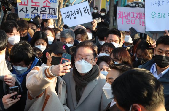 [서울=뉴시스] 국회사진기자단 = 이재명 더불어민주당 대선 후보가 21일 서울 마포구 연남동 거리를 방문해 시민들과 기념촬영을 하고 있다. 2022.01.21.