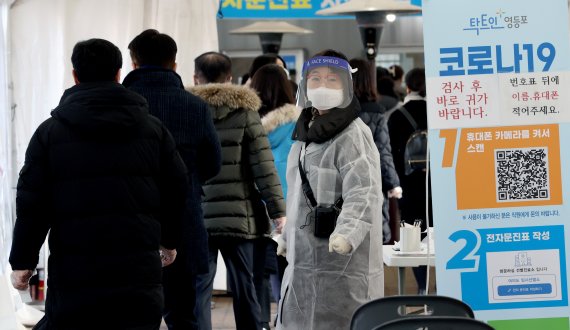 24일 오전 서울 여의도동 여의도공원 임시선별검사소에서 의료진이 검사를 기다리는 시민들을 통제하고 있다. 뉴시스 제공
