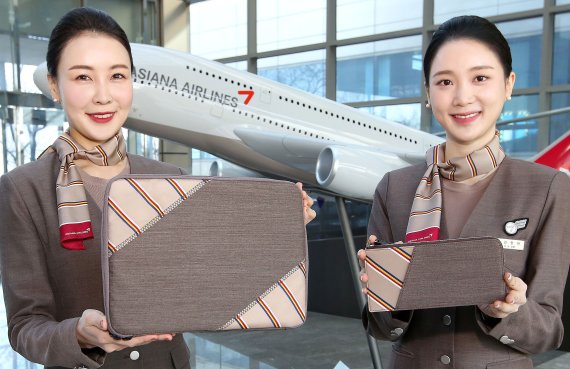 아시아나항공 승무원들이 회수한 유니폼을 이용해 제작한 업사이클링 제품인 태블릿 파우치를 소개하고 있다. 아시아나항공 제공