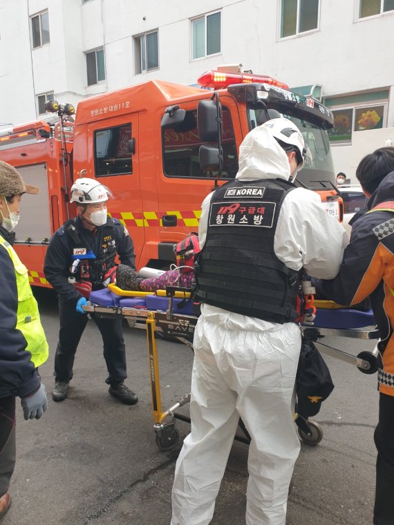 [창원=뉴시스] 강경국 기자 = 경남 창원시 성산구 중앙동 원룸건물에서 25일 오후 4시8분께 화재가 발생해 119구조대원들이 부상자를 옮기고 있다. (사진=창원소방본부 제공). 2022.01.25. photo@newsis.com *재판매 및 DB 금지