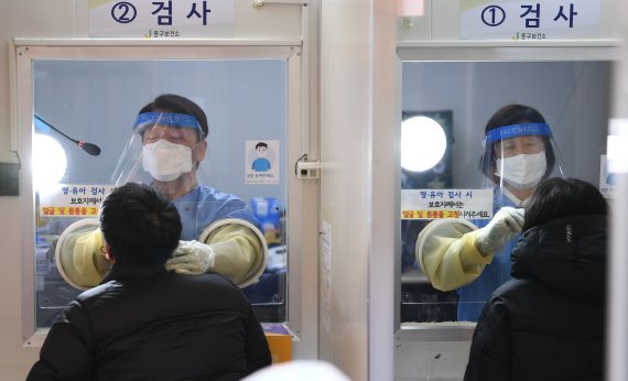 안철수 국민의당 대선 후보가 설 연휴 마지막 날인 2일 서울 중구보건소 선별진료소에서 부인 김미경 교수와 함께 코로나19 검체 채취 의료봉사 활동을 하고 있다. 이날 동행한 딸 안설희 박사는 행정 업무 등을 지원했다. 2022.2.2/뉴스1 © News1 오대일 기자