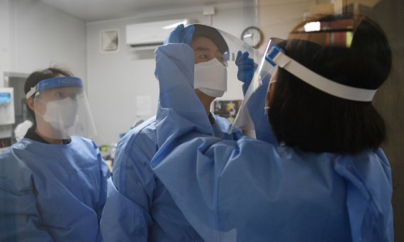 안철수 국민의당 대선 후보가 설 연휴 마지막 날인 2일 서울 중구보건소 선별진료소에서 부인 김미경 교수, 딸 안설희 박사와 함께 코로나19 의료 봉사를 위해 페이스 쉴드를 착용하고 있다. 이날 안 후보 부부는 검체 체취를, 딸 안설희 박사는 행정 업무 등을 지원했다. 2022.2.2/뉴스1 © News1 오대일 기자